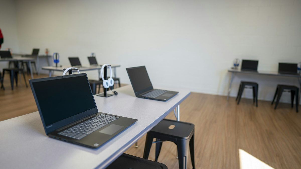 Laptops set up on classroom desks