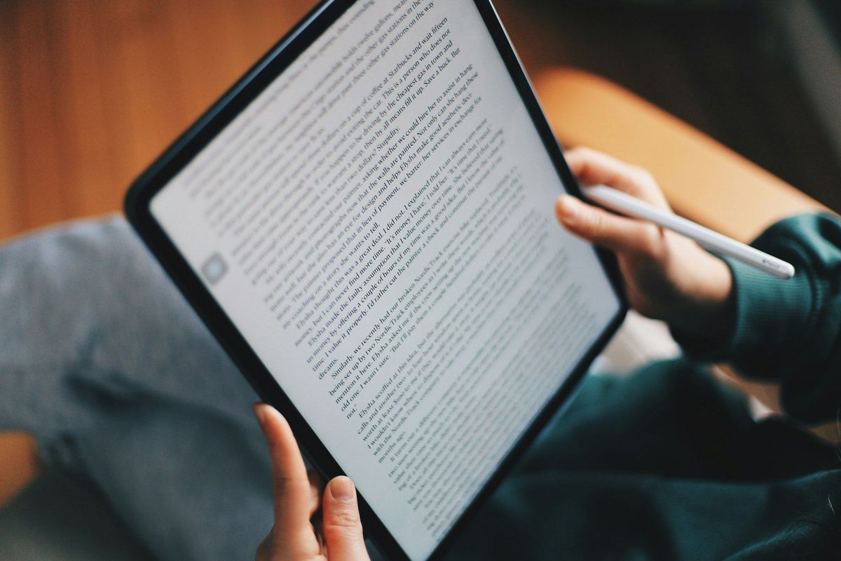 Student writing on an iPad with a pencil